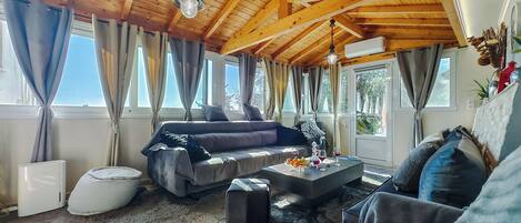 Relax in this airy living area with a comfortable sofa set and exposed wooden beams.