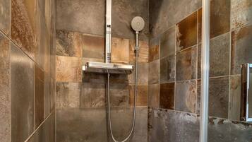 Eine Dusche mit Handbrause und einer fest installierten Bedienpanel.