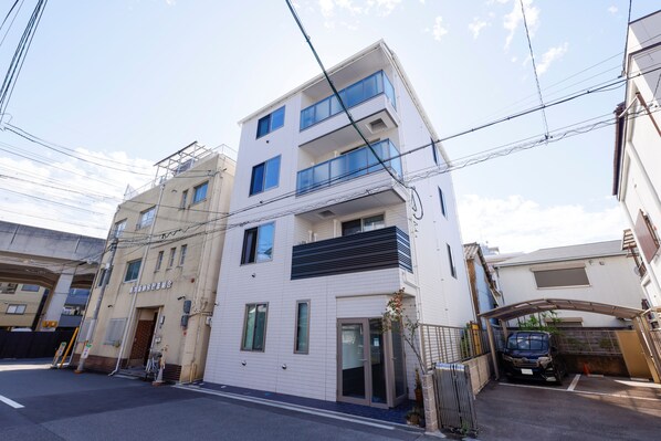 A multi-story residential building with a modern design, featuring balconies and large windows.