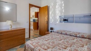 Ein Schlafzimmer mit einem Bett, einem Schminktisch, einem Spiegel und einer Tür zu einem Badezimmer.