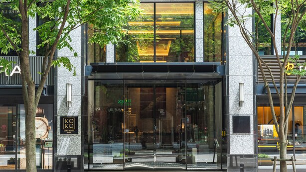 A modern hotel entrance with large glass doors, a clock, and a sign indicating the hotel name. - KOKO HOTEL Premier Kanazawa Korinbo (Kanazawa)