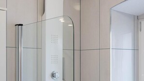 A modern shower enclosure with a curved showerhead, a handheld showerhead, and a control panel. - Room-stephane City Vibe Suites - Double (Trogir)