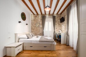 A bedroom with a bed, bedside table, and a desk with a chair. - Room-stephane City Vibe Suites - Superio (Trogir)