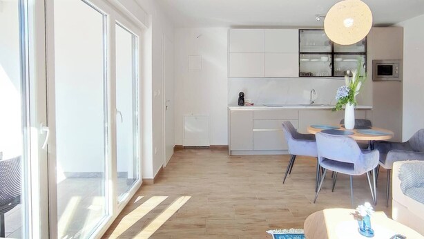 A modern apartment with a dining area, kitchen, and living room. - Basilea Superior Apartment (Malinska-Dubasnica)
