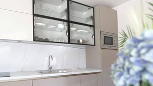 A modern kitchen with a marble countertop, a built-in sink, and a glass-fronted cabinet above the sink. - Basilea Superior Apartment (Malinska-Dubasnica)