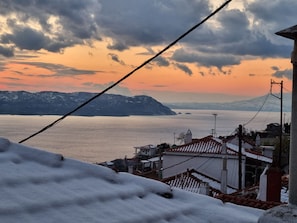 Une vue sur la côte, avec des toits recouverts de neige et un ciel dégagé.