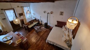 Un cuarto acogedor y rústico con pisos y muebles de madera, una chimenea y lámparas colgantes.