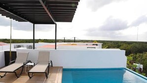 A rooftop pool area with lounge chairs and a covered seating area. - One Bedroom Penthouse In The Exclusive Aldea Zama (Tulum)