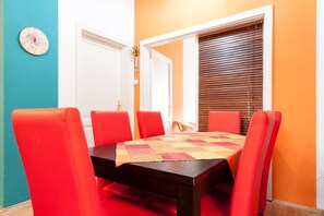 A dining area with a table, chairs, and a clock on the wall. - Vibrant 3 Bedroom Apartment In The Pulsing Heart Of Budapest (Budapest)