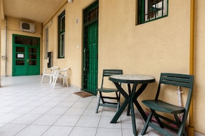 Relax in this serene outdoor seating area with a small table and two comfortable chairs.