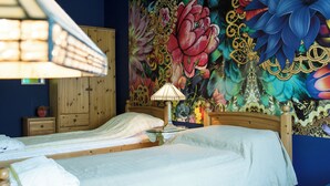 A bedroom with a bed, a nightstand, a lamp, and a wooden wardrobe. - Vibrant 3 Bedroom Apartment In The Pulsing Heart Of Budapest (Budapest)