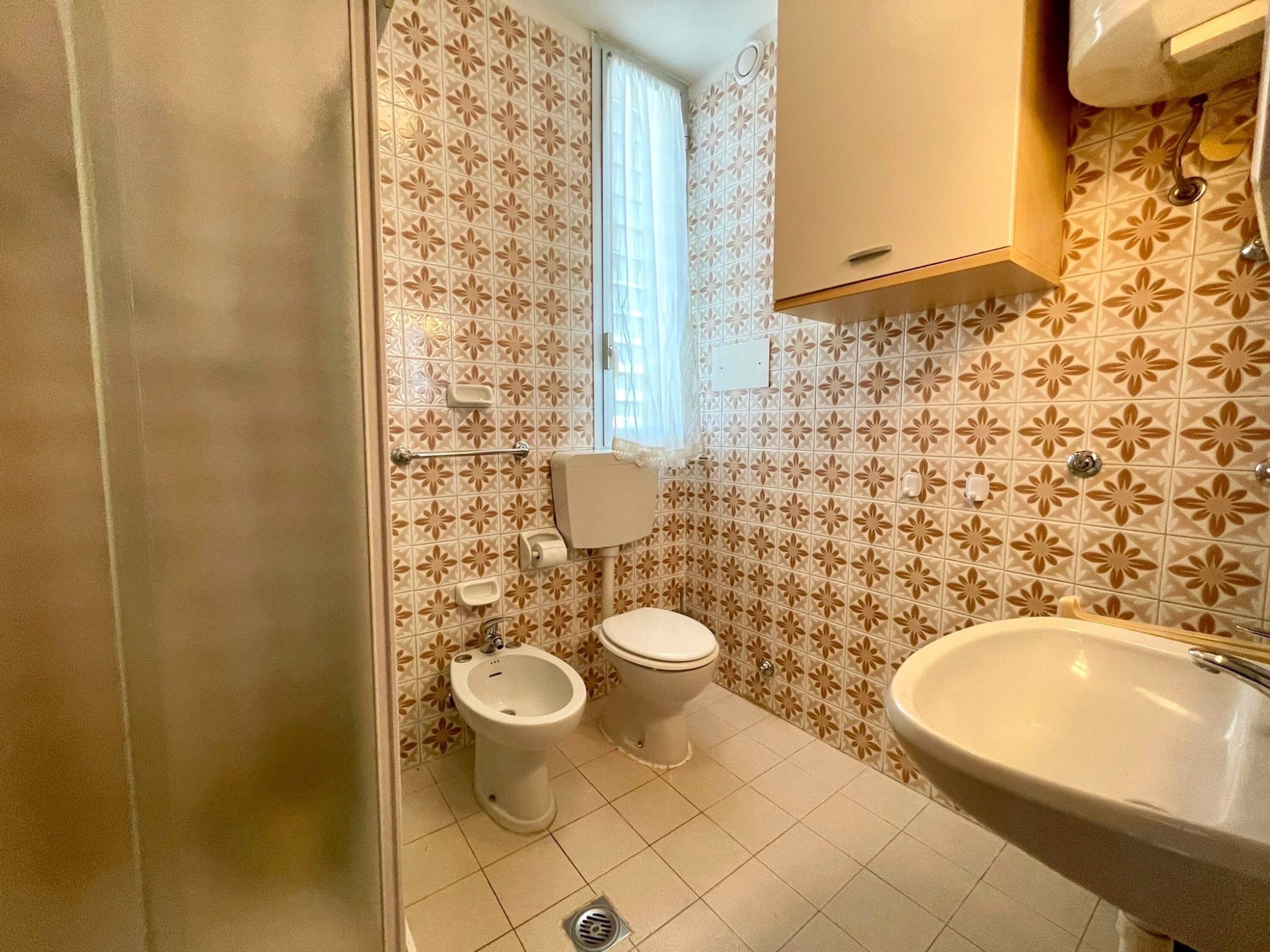A bathroom with a toilet, bidet, and sink.
