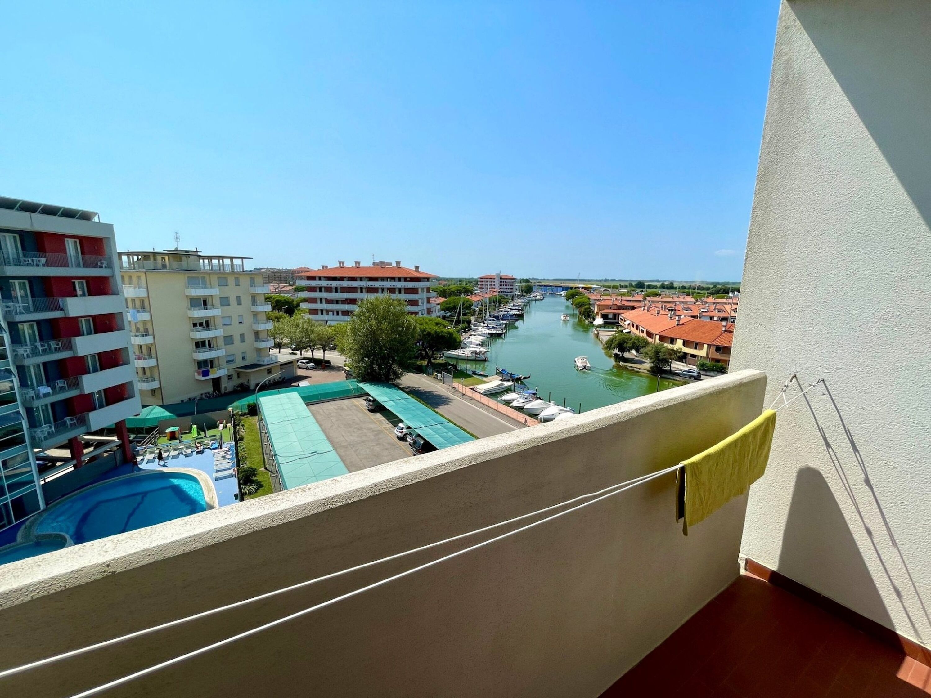 A balcony with a view of a marina, buildings, and a river.