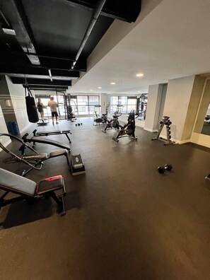 Une salle de sport équipée de divers appareils d’exercice, notamment des tapis de course, des vélos d ’appartement et des appareils de musculation.