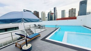 Ein Pool auf dem Dach mit Blick auf eine Stadtlandschaft im Hintergrund.