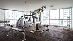 Ein Fitnessraum mit Trainingsgeräten, Laufband und einer Bank.