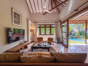 A spacious living area with a television, a coffee table, and comfortable seating.