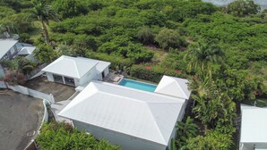 Et boligområde med huse, swimmingpool og frodig beplantning.