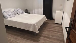 Ein Schlafzimmer mit einem Bett, einem Nachttisch und einem kleinen weißen Schrank.