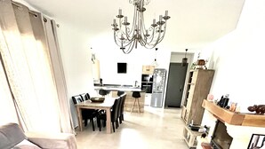 Ein modernes Wohnzimmer mit einer Couch, einem Holztisch und einer Deckenleuchte.