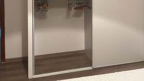 Ein begehbarer Kleiderschrank mit Kleiderstange und Ablagefläche.
