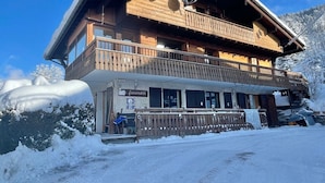 Un bâtiment en bois à deux étages, doté d’un balcon, d’une enseigne indiquant le nom « Farandree » et surplombant un paysage enneigé.