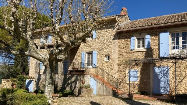 A stone building with a staircase leading to a balcony, surrounded by trees and a garden. - Today's comfort in yesterday's mas in the heart of Provence (Suze la Rousse)