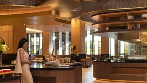 A modern hotel lobby with a central reception desk, wooden paneling, and large windows. - Asawin Grand Convention Hotel (Bangkok)