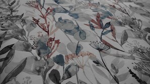 Un letto con biancheria e cuscini a motivi floreali.