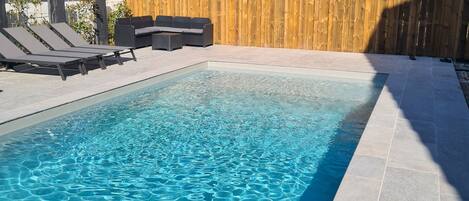 Una piscina al aire libre, una piscina climatizada