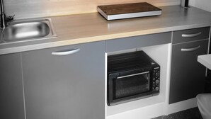 Una cucina moderna con forno a microonde, forno e lavello integrati.