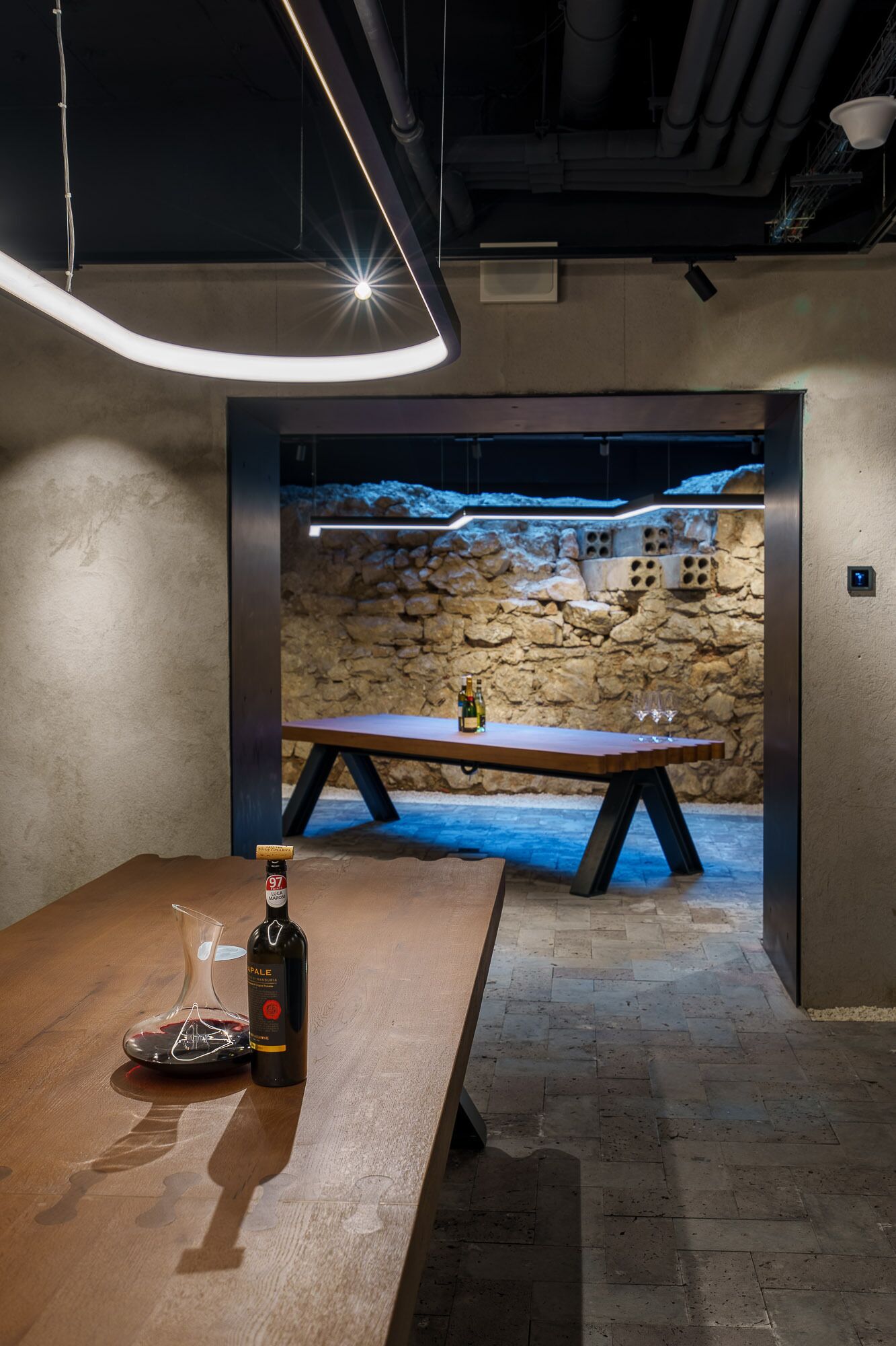 Un intérieur moderne avec une table en bois, une bouteille de vin et un verre à vin.