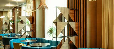 Un interior moderno con asientos azules, paneles de pared geométricos e iluminación única.