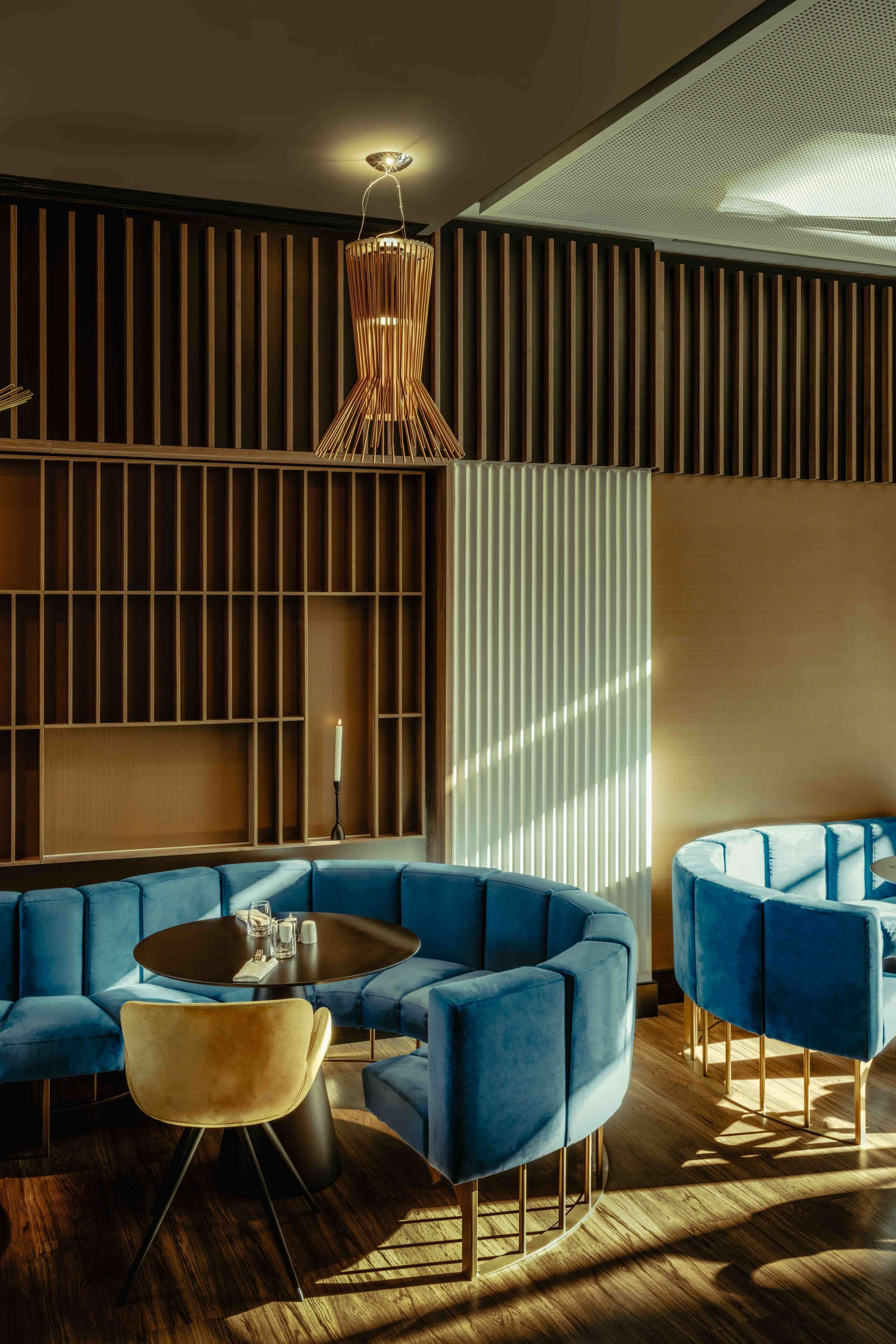 A modern living room with a sectional sofa, a round coffee table, and a unique hanging light fixture.