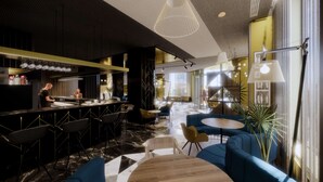 A modern bar area with a bar counter, seating, and a staircase leading to an upper level.