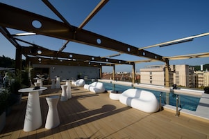 Una piscina al aire libre de temporada, sombrillas