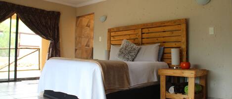 A bedroom with a bed, a nightstand, and a small wooden table.