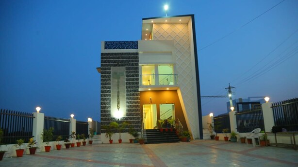 A modern two-story building with a well-lit entrance and a paved courtyard. - GP Residency (Gingee)
