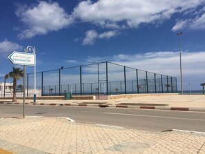 A fenced area with a clear view of the sea, a sign indicating 'Quartier Haouat Al Bahr', and a paved walkway. - Top Floor Private Terrace with Sea View (Oued Laou)