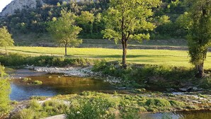 A natural landscape with a river, trees, and a grassy field. - Village house and garden, breathtaking view (Saint-Sauveur-de-Cruzières)