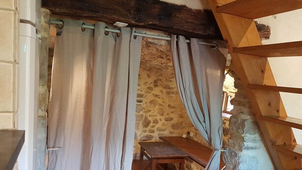 A rustic room with stone walls, a wooden bench, and a curtain. - Village house and garden, breathtaking view (Saint-Sauveur-de-Cruzières)