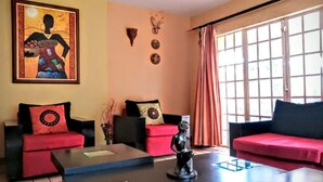 Una sala de estar con dos sofás rojos, una mesa de centro y un cuadro en la pared.