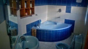 Un baño con bañera, lavabo e inodoro.