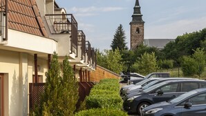 A row of modern buildings with a church tower in the background.
