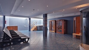 A modern lobby with a seating area, a staircase, and a reception desk.
