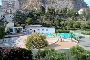 A resort with a swimming pool, outdoor seating, and a mountainous backdrop. - Hotel Terme Sibarite (Cassano allo Ionio)