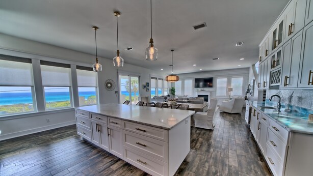 A spacious kitchen with a large island, white cabinetry, and a view of the ocean. - The Hidden Gem ~Luxurious Beachfront Home Near 30A! (Panama City Beach)