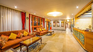 Amplia sala de estar con un conjunto de sofás, una mesa de centro y un mostrador de recepción.