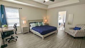 A bedroom with a bed, bedside tables, a desk, a chair, and a mirror. - Welcome to Beachy Bliss – Your Emerald Waters Escape! (Navarre)