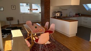 A compact living space with a dining area, kitchen, and a small island.